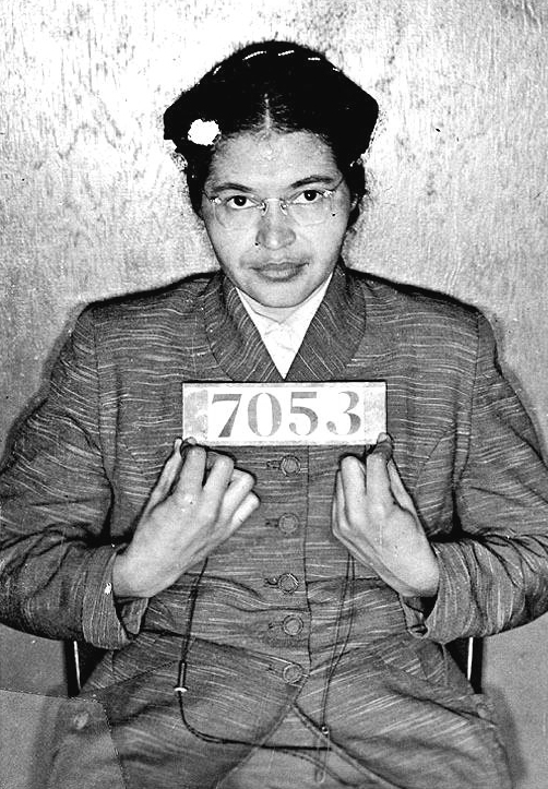 A woman seated and holding a sign with numbers on it