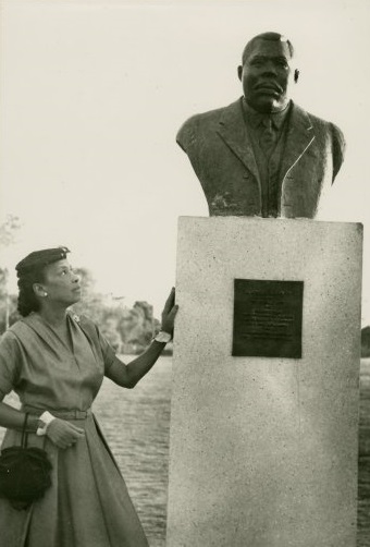 A woman resting her hand on a statue